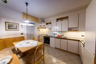 a kitchen with a table and a dining room at Casa Trettel in Tesero