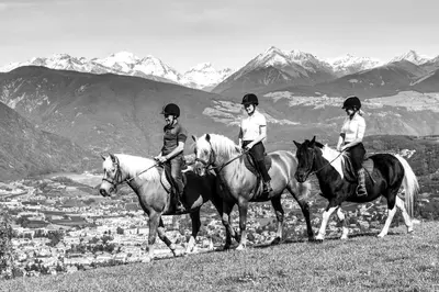 three people are riding horses on a hill at Widmannhof - Urlaub auf dem Biobauernhof in Bressanone