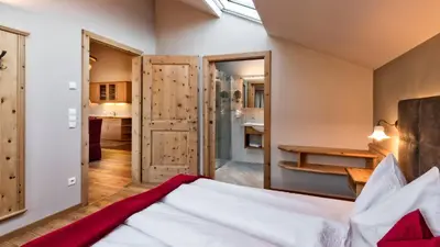 a bedroom with a bed and a bathroom at Widmannhof - Urlaub auf dem Biobauernhof in Bressanone