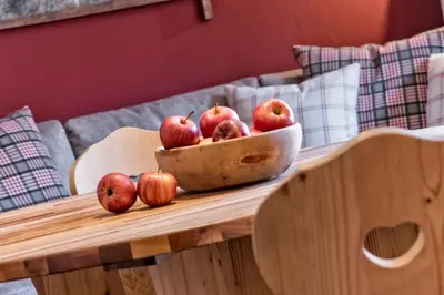 a bowl of apples sitting on a wooden table at Widmannhof - Urlaub auf dem Biobauernhof in Bressanone