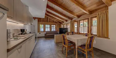 a kitchen with a table and chairs in a room at Appartamenti Stefan in Campitello di Fassa