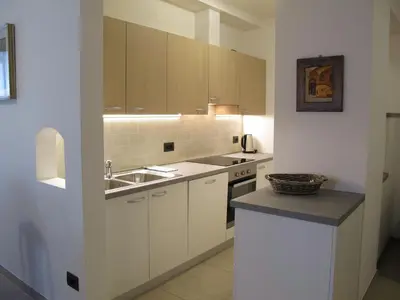 a kitchen with white cabinets and a sink and a counter at Appartamenti Stefan in Campitello di Fassa