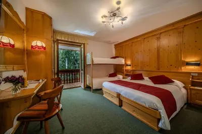 a hotel room with a bed and a desk and a desk at Hotel il Cardo in San Vito di Cadore
