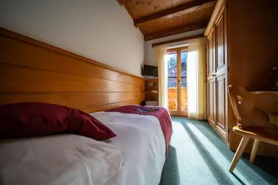 a bedroom with two beds and a window at Hotel il Cardo in San Vito di Cadore