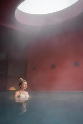 a woman is standing in a bath tub at The Oswald Grand Hotel in Selva di Val Gardena