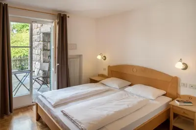 a bedroom with a large bed and a balcony at Residence Diamant in Castelrotto