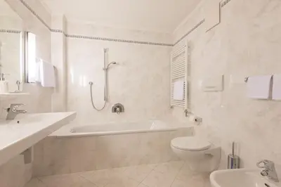 a bathroom with a tub and a toilet and a sink at Residence Diamant in Castelrotto