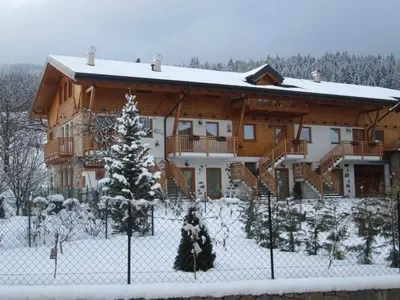 a building with snow on the ground in front of it at Agriturismo Pisani in Brez
