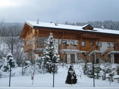 a snow covered building with a fence in front of it at Agriturismo Pisani in Brez