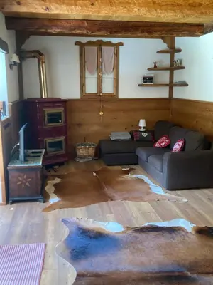 a living room with a couch and a tv at Chalet nel cuore delle Dolomiti in Falcade