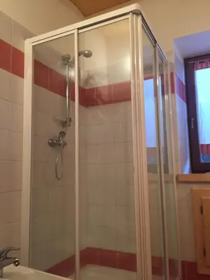 a shower with a glass door in a bathroom at Chalet nel cuore delle Dolomiti in Falcade