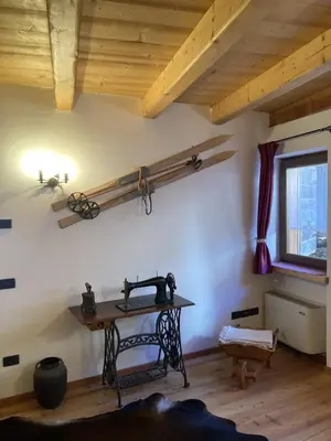 a room with a table and a window and a wooden ceiling at Chalet nel cuore delle Dolomiti in Falcade
