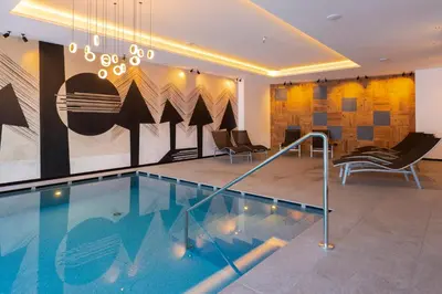 a hallway with a glass wall with blue lights at Monza Dolomites Hotel in Moena