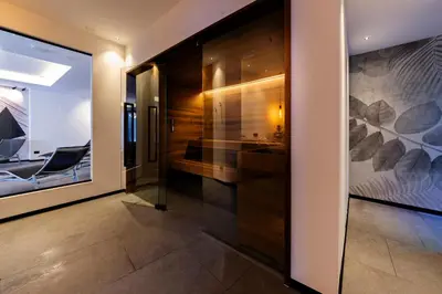 a large swimming pool in a room with chairs at Monza Dolomites Hotel in Moena