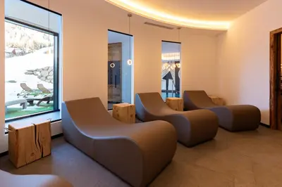 a bedroom with two beds and a tub at Monza Dolomites Hotel in Moena