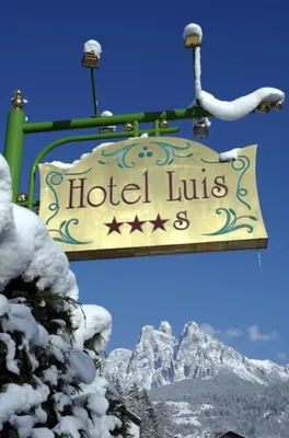a sign on a ski lift with a snow covered mountain at Hotel Luis in Fiera di Primiero