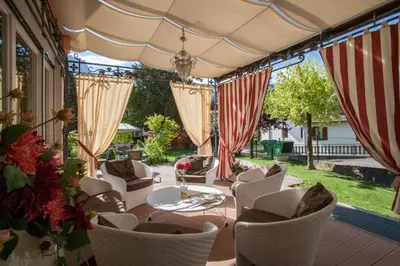 an outdoor patio with a table and chairs at Hotel Luis in Fiera di Primiero