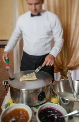 a man cooking food in a pot on a stove at Hotel Luis in Fiera di Primiero
