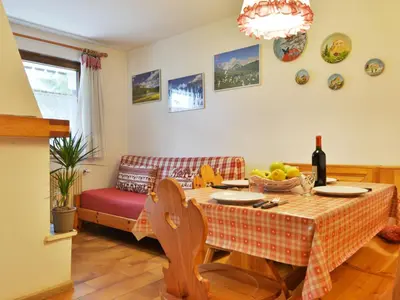 a dining room with a table and a couch at Apartment Monti Pallidi by Interhome in Campitello di Fassa