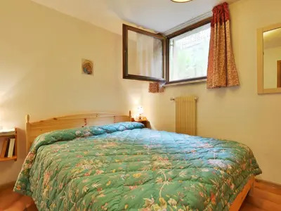 a bedroom with a bed with a green comforter and a window at Apartment Monti Pallidi by Interhome in Campitello di Fassa