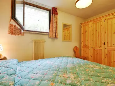 a bedroom with a blue bed and a window at Apartment Monti Pallidi by Interhome in Campitello di Fassa
