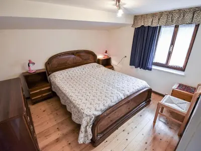 a bedroom with a bed in a room with wooden floors at Apartment La Busa-3 by Interhome in Alleghe