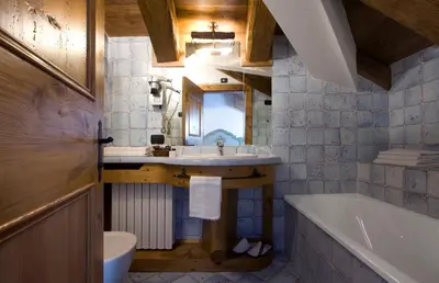 a bedroom with a large bed with a large headboard at Hotel Cortina in Cortina dʼAmpezzo