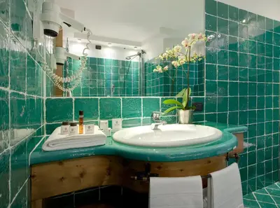 a bathroom with a tub and a sink and a bath tub at Hotel Cortina in Cortina dʼAmpezzo