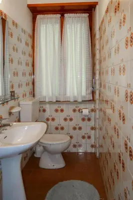 a bathroom with a white toilet and a sink at Apartment Pancheri by Interhome in Coredo