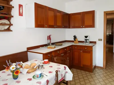 a kitchen with wooden cabinets and a table with food on it at Apartment Pancheri by Interhome in Coredo
