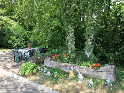 a garden with a table and a flower bed with flowers at Apartment Pancheri by Interhome in Coredo