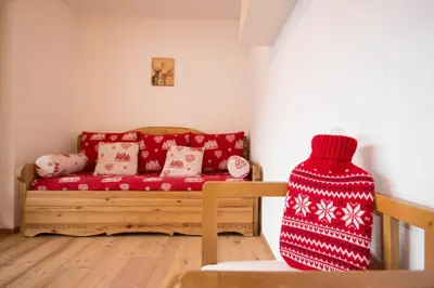 a living room with a red couch and a red blanket at Aurturist Valdaora Roulette in Valdaora