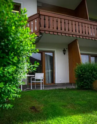 a house with a balcony and a table and a chair at Hotel Digon in Ortisei