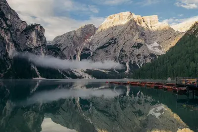a mountain reflecting in a lake in front of a mountain at Hotel Digon in Ortisei