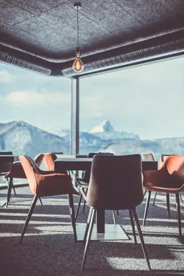a table and chairs in front of a large window at Spaces Hotel in San Vigilio Di Marebbe