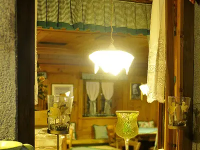 a room with a mirror and two glasses and a lamp at Hotel Belvedere wellness in Falcade