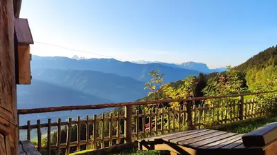a wooden bench sitting on top of a hill overlooking a lake at Masitterhof in Bressanone