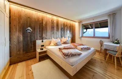 a bedroom with a bed and a wooden wall at Masitterhof in Bressanone