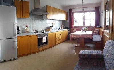 a kitchen with a table and a white refrigerator at Masitterhof in Bressanone