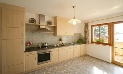 a kitchen with wooden cabinets and a window at Masitterhof in Bressanone
