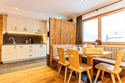 a kitchen and dining room with a table and chairs at Apartments Milanhof in Ortisei