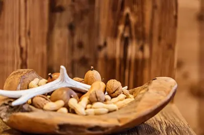 a wooden bowl filled with nuts on a wooden table at Apartments Milanhof in Ortisei