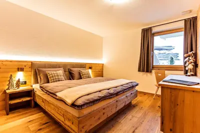 a bedroom with a large bed with a window at Apartments Milanhof in Ortisei