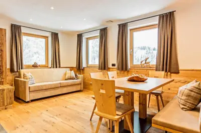 a living room with a table and a couch at Apartments Milanhof in Ortisei