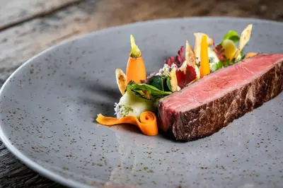 a plate with a piece of meat and vegetables on it at Avidea - Adults Only in Lagundo