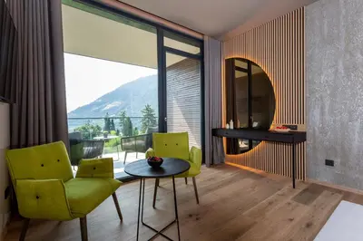 a living room with a table and chairs and a large window at Avidea - Adults Only in Lagundo