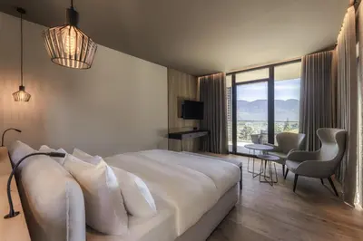 a hotel room with a large bed and a table and chairs at Avidea - Adults Only in Lagundo