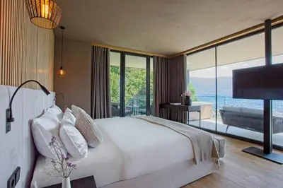 a bedroom with a large white bed and a large window at Avidea - Adults Only in Lagundo