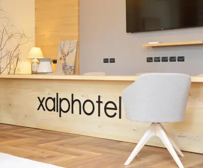 a white chair sitting in front of a reception desk at X Alp Hotel in Pozza di Fassa