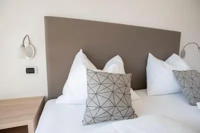 a bedroom with a bed with white pillows at Residence Roland in Caldaro